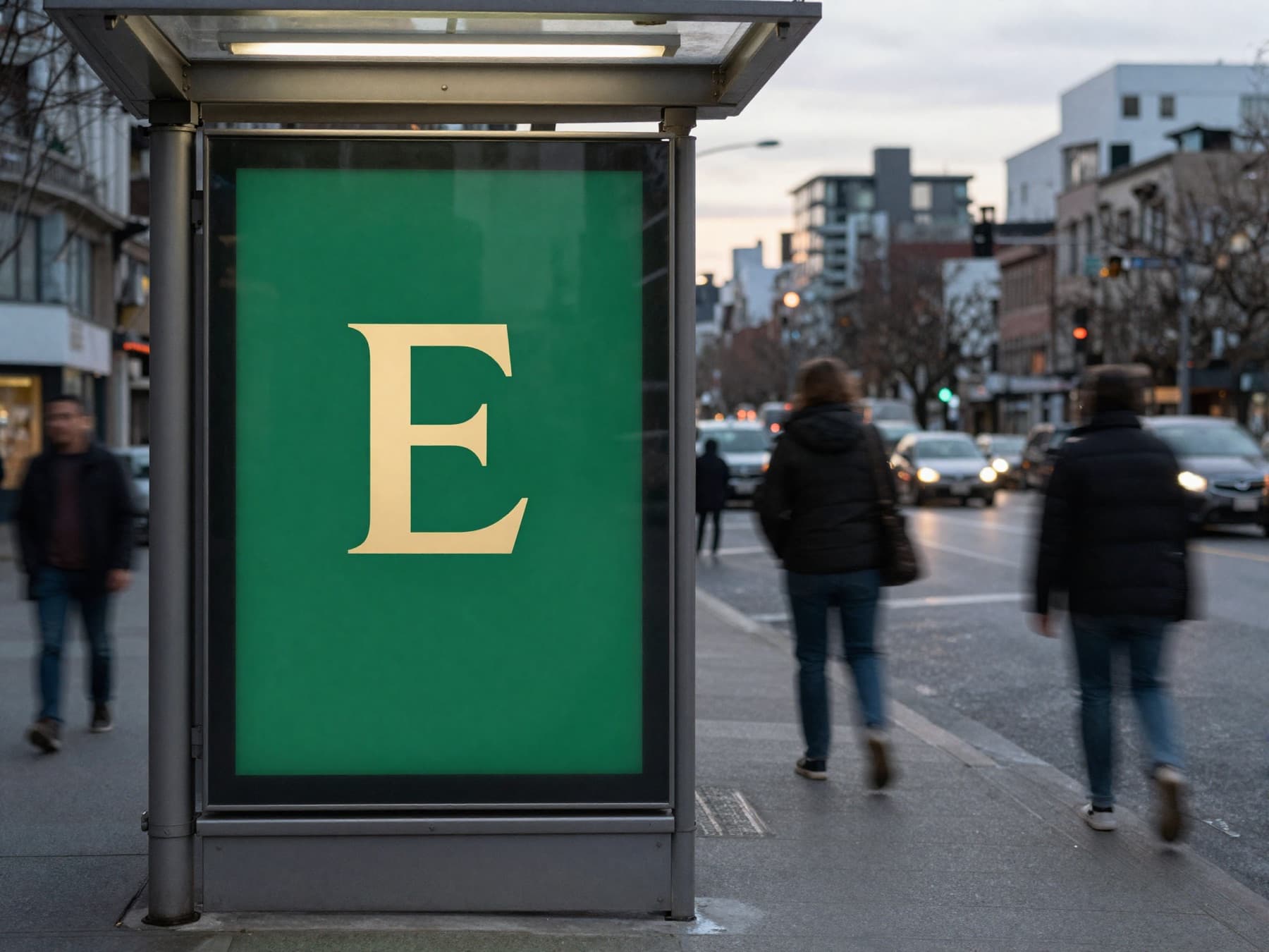 Transit shelter panel with the Ermete monogram at blue hour